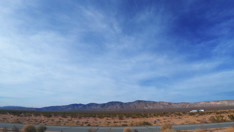 Looking-out-the-side-window-as-the-vehicle-travels-through-the-Mojave-Desert-landscape---passenger-point-of-view-hyperlapse