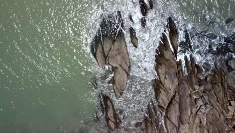 Luftaufnahme-Von-Oben-Nach-Unten-Aus-Der-Vogelperspektive-Von-Generischen-Meereswellen,-Die-Auf-Felsen-Krachen