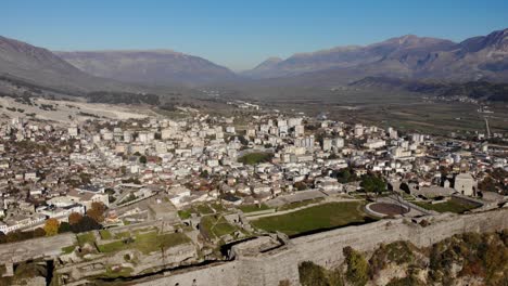Castle-of-Gjirokastra-built-on-hill-over-city-in-valley-surrounded-by-mountains