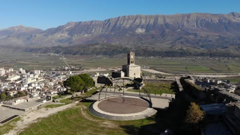 Schloss-Von-Gjirokastra-In-Albanien-Mit-Uhrturm-Und-Steinmauern-über-Der-Stadt,-Berghintergrund