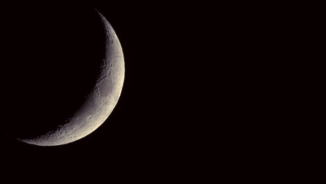 Close-up-of-the-waning-crescent-moon-with-craters-visible-slowly-rotating---night-time-lapse