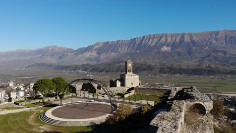 Castle-of-Argjiro-with-clock-tower-and-festival-scene-surrounded-by-stone-walls-in-Gjirokaster,-Albania