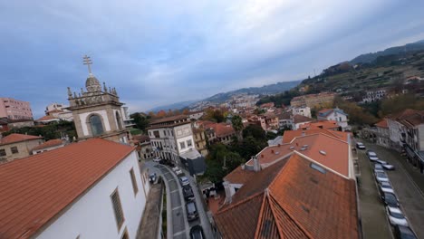 Aerial-high-speed-panoramic-view-over-Amarante-roofs-and-Tamega-river,-Portugal