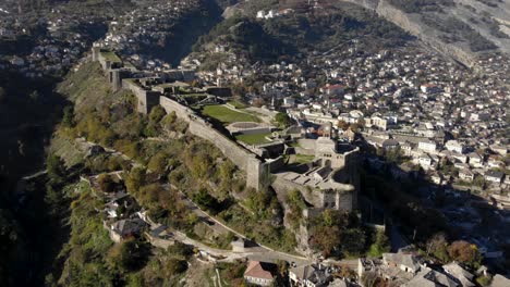 Schloss-Von-Gjirokaster-Mit-Steinmauern-Und-Hohem-Uhrturm-Auf-Hügel-über-Stadthäusern
