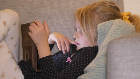 Junges-Mädchen,-Das-Auf-Der-Couch-Liegt-Und-Videos-Auf-Dem-Tablet-Ansieht,-Reagiert-Mit-Nervöser-Besorgnis