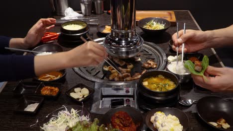 Two-People-Eating-Samgyeopsal-For-Dinner-In-A-Korean-Restaurant---close-up,-static-shot