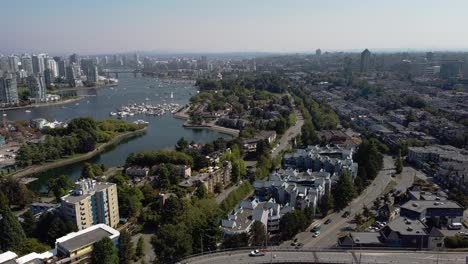 Aerial-hold-over-300-ft-above-Granville-Island-False-Creek-Residents-on-hot-summer-day-viewing-low-rise-waterfront-homes-townhouses-bridged-at-luxury-condominium-commercial-offices-dead-quiet-boats1-2
