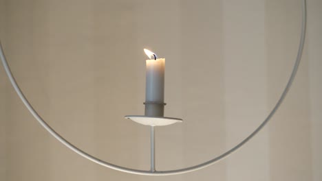 Close-view-of-flame-being-blown-out-on-white-hanging-candle-holder