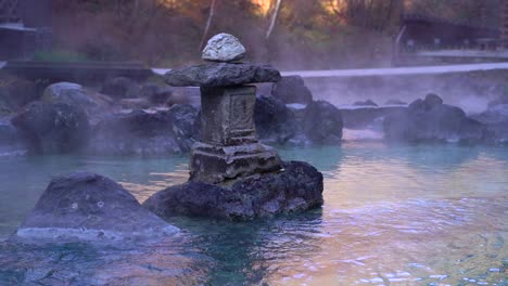 Stone-pillar-inside-natural-Japanese-hot-spring-with-steaming-hot-water