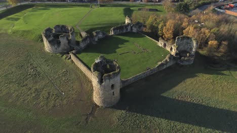 Historical-Flint-castle-medieval-military-ruins-landmark-aerial-view-rising-tilt-down
