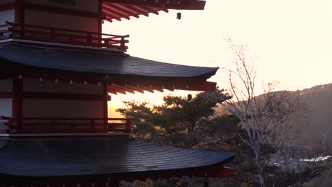 Silhouette-of-Japanese-Pagoda-against-sunset-sky-on-clear-day-in-slow-motion