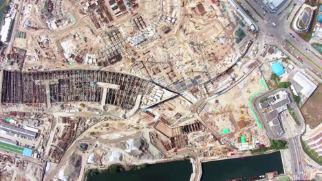Mega-Construction-project-of-a-Housing-and-business-district-at-Kai-Tak-downtown-Hong-Kong,-with-vast-infrastructure-development-land-and-an-underwater-tunnel-laying-operation,-Aerial-view