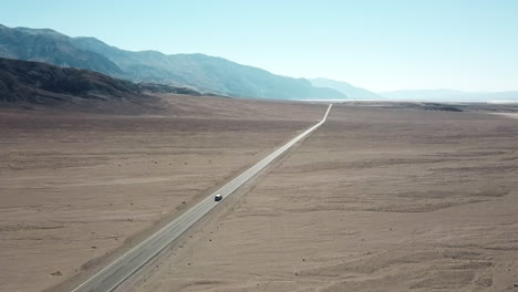 Tracking-Luftaufnahme-Eines-Autos,-Das-Auf-Der-Badwater-Road-Im-Death-Valley-National-Park-Fährt