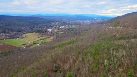 A-drone-flying-over-the-Appalachians-near-sunset-with-farmland-and-houses-way-below