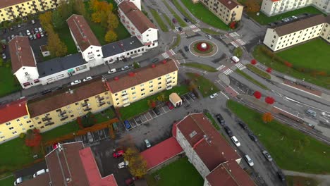 Colorful-buildings-and-roundabout-traffic,-Aerial-static