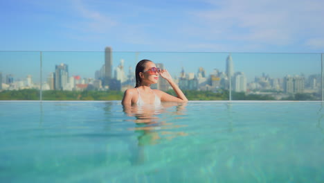 Junge-Asiatische-Frau-Mit-Großer-Sonnenbrille,-Die-Sich-Beim-Baden-Im-Pool-Entspannt