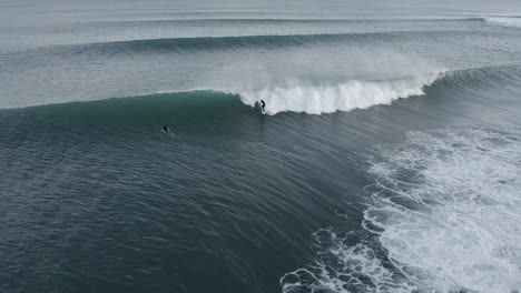 Skillful-surfer-rides-massive-wave-in-cold-Atlantic-Ocean,-aerial