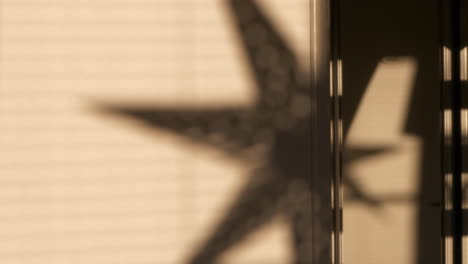 Timelapse-of-shadow-of-christmas-decoration-star-moving-on-wall-inside