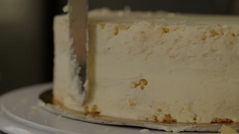 Close-up-of-frosting-the-sides-of-a-vanilla-sponge-cake