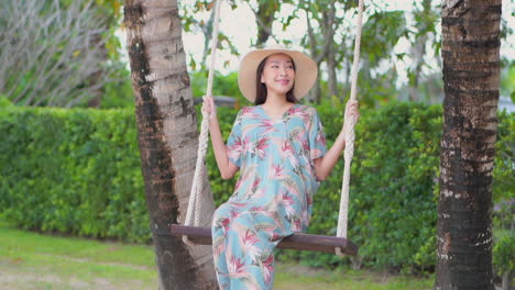 Adult-Asian-Woman-Swinging-Happily-on-Swing-Beneath-Tree