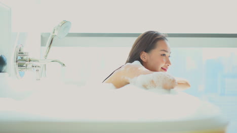 Schöne-Junge-Asiatische-Thailändische-Frau-Entspannt-Sich-In-Der-Badewanne-Mit-Schaum
