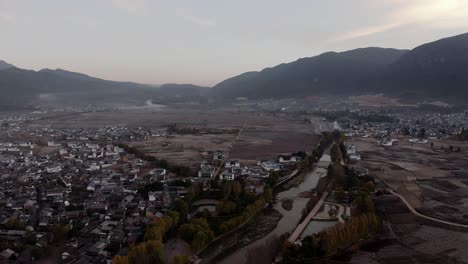 Ländliche-Traditionelle-Chinesische-Stadt-Im-Tal-Der-Landschaft-Von-Yunnan,-Sonnenaufgang-Aus-Der-Luft