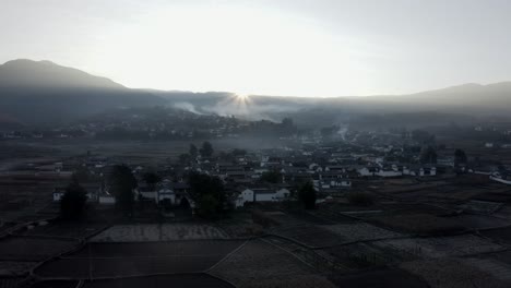 Beautiful-misty-sunrise-over-historic-Chinese-Shaxi-town-in-Yunnan,-aerial-view
