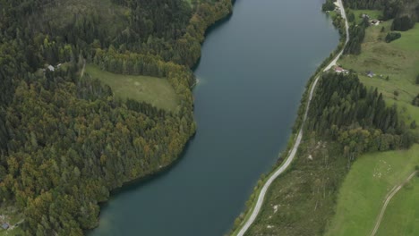Top-view-of-Freibach-reservoir-in-Austria-with-rural-village-homes,-Aerial-tilt-up-reveal-shot