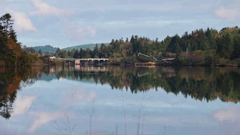 Lumber-Mill-Near-Bridge-In-Coos-Bay,-Oregon-With-Water-Reflections---wide-static-shot