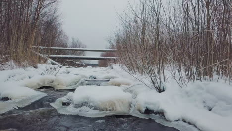 Ice-and-snow-over-frozen-water-stream-in-Lapland,-Finland