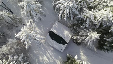 Cabins-Roof,-Reveal-a-Second-Cabin-in-Woods-During-Winter,-Top-Down-Aerial