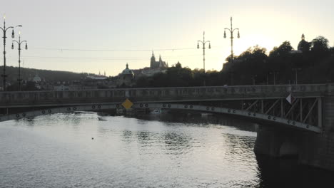 Tráfico-En-Un-Puente-De-Acero-Sobre-El-Río-Moldava-Al-Atardecer,-Praga,-República-Checa