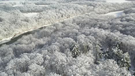 Fairytale-Snow-Covered-Treetops-Reveal-River,-Winter-Season-Concept,-Aerial