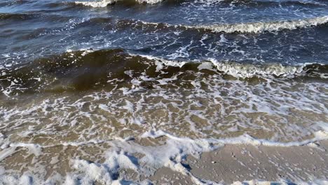 Die-Wellen-Entlang-Der-Küste-Rollen-Langsam-über-Den-Sand