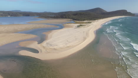 Cinematic-wide-rotating-drone-shot-of-Sandbar-Beach-and-Smith-Lake-in-New-South-Wales-Australia