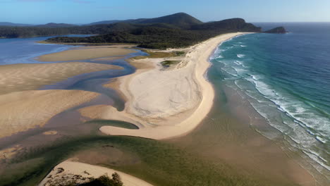 Cinematic-wide-revealing-drone-shot-of-Sandbar-Beach-and-Smith-Lake-in-New-South-Wales-Australia