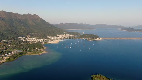 Hong-Kong-bay-with-small-boats-and-surrounding-green-landscape,-aerial-view