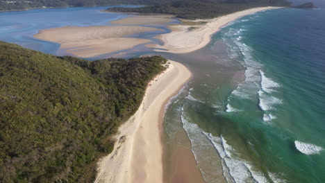 Cinematic-tilting-up-drone-shot-of-Sandbar-Beach-and-Smith-Lake-in-New-South-Wales-Australia