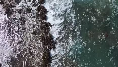 Wellen,-Die-über-Felsen-Krachen,-Luftdrohne-Blaues-Wasser