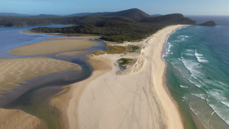 Wide-revealing-drone-shot-of-Sandbar-Beach-and-Smith-Lake-in-New-South-Wales-Australia