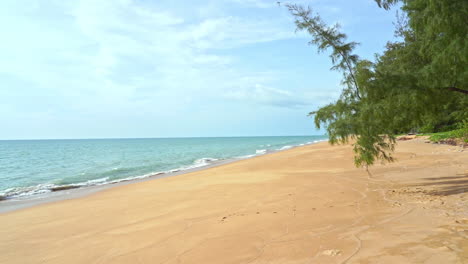 Static-shot-of-clean-white-sand-beach-and-calm-ocean-with-no-people-in-the-shot-during-bright-sunny-day