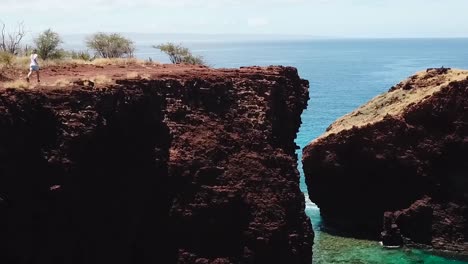 Drone-aerial-Hawaii-man-running-on-cliffside-success
