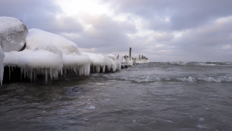 Frozen-Old-Pier-With-Soft-Rolling-Waves-In-The-Baltic-Sea---Medium-Shot,-Static