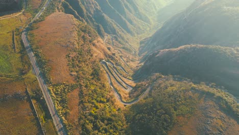 Top-down-view-of-mountain-rainforest-road,-Serra-Do-Rio-Do-Rastro-and-the-mountains-of-Santa-Catarina-at-sunrise