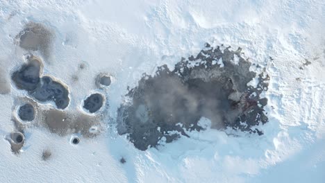 Top-down-of-active-fumarole-in-white-winter-landscape,-Gunnuhver