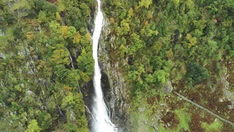 Idyllic-Snowdonia-mountain-range-Aber-falls-waterfalls-national-park-aerial-view-rising-pull-away