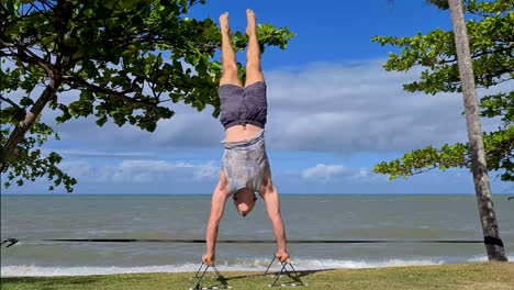 Young-Adult-Male-Doing-Handstand-On-Trinity-Beach,-Cairns