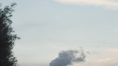 Tilt-down-to-Smoking-factory-chimney-at-sunset---120-fps-slow-motion