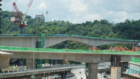 Construction-site-of-new-bridge-with-crane-over-freeway-intersection-road-circle-in-Asia