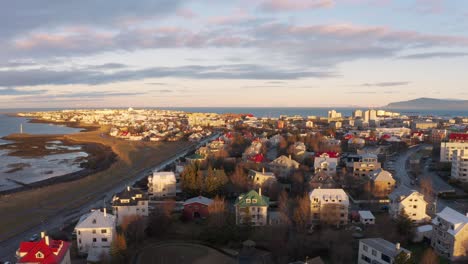 Drone-flying-over-Beautiful-Houses-By-The-Coast-In-Reykjavik-Iceland---aerial-shot